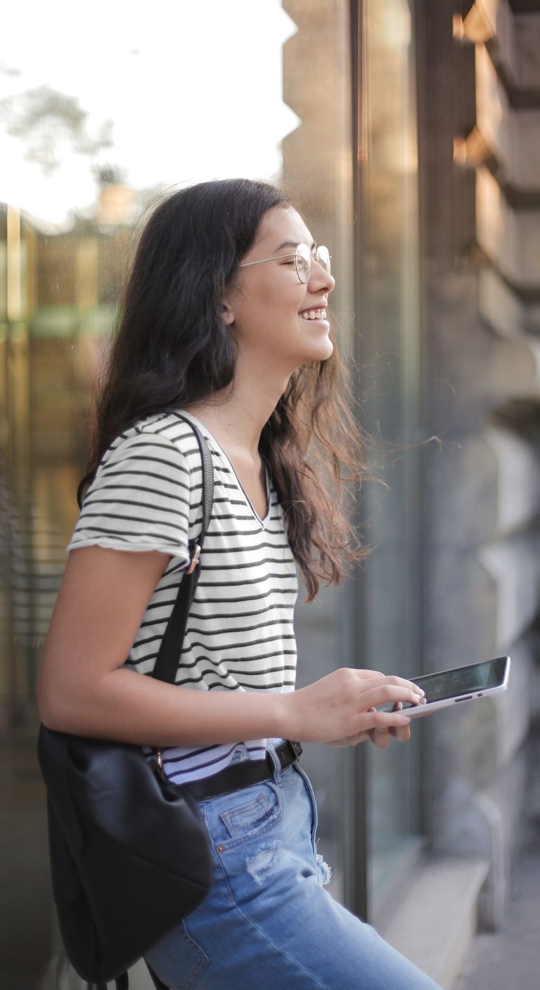 Smiling resident requesting a visitor pass on her mobile device at the entrance of her building